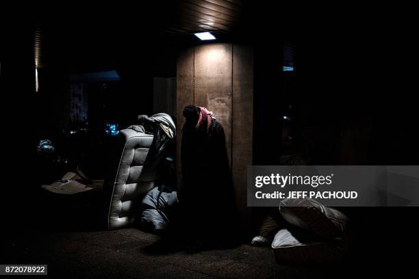 Minor poses in a makeshift camp where he spend his nights, on November 7, 2017 in a street of Lyon. - Migrants gather in this makeshift camp and wait...