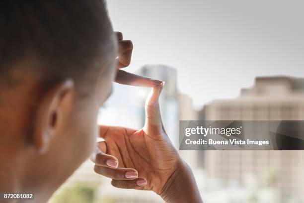 business woman framing building with fingers - finger frame stock-fotos und bilder