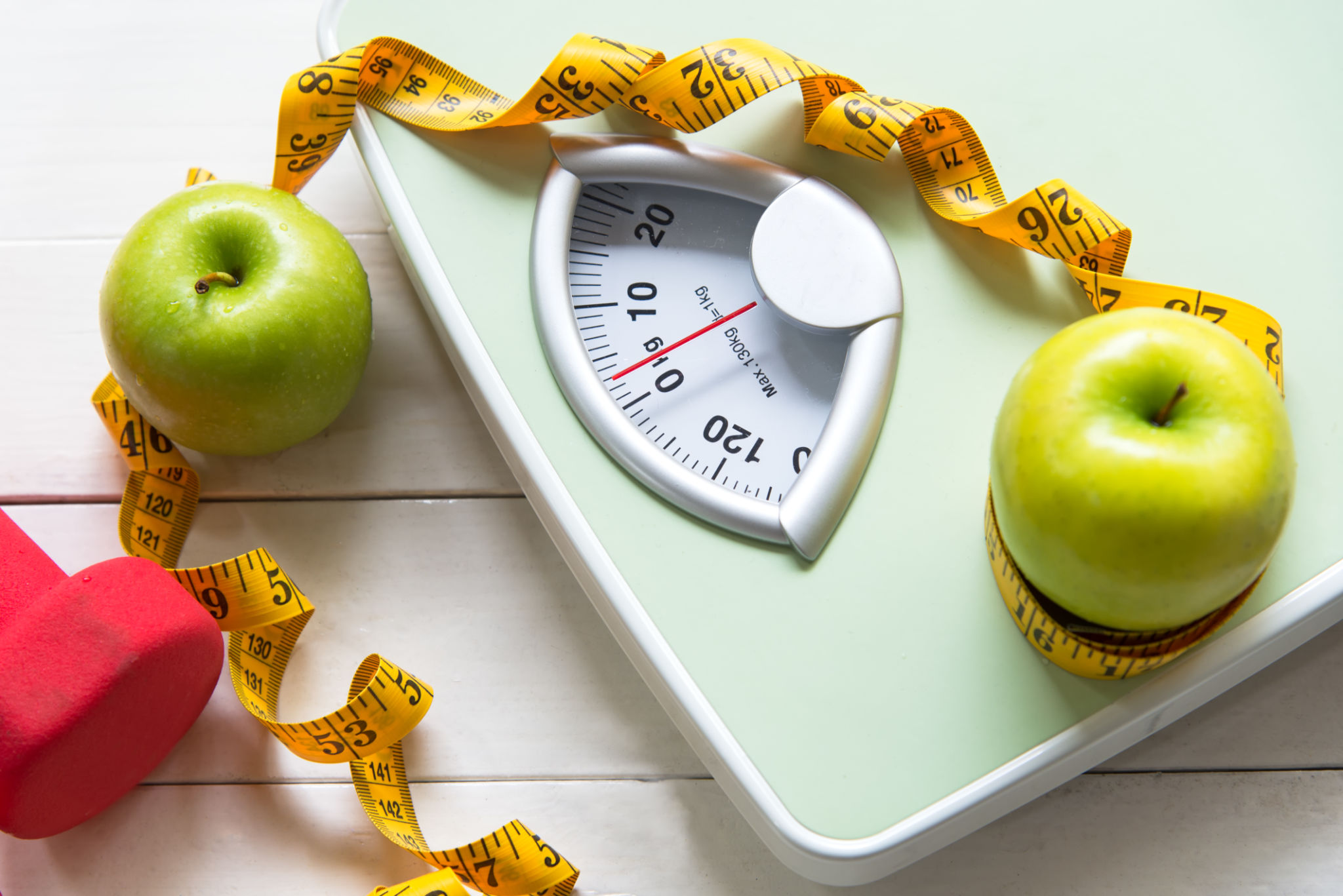 Green apple with weight scale and measuring tape for the healthy diet slimming . Diet and Healthy Concept Green apple with weight scale and measuring tape for the healthy diet slimming . Diet and Healthy Concept