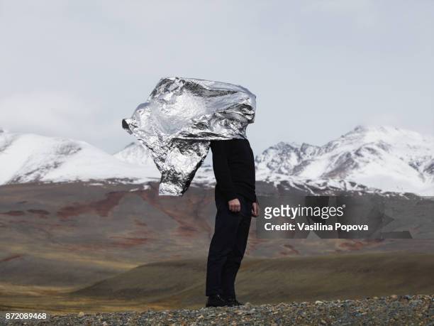 Man covered with foil against nature background