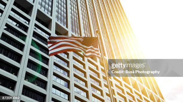 new york city, ny, usa - october 11, 2017: american flag flapping in front of corporate office building in lower manhattan - palazzo governativo foto e immagini stock