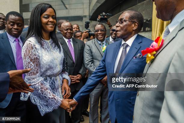 Zimbabwean President Robert Mugabe is congratulated by First Lady Grace Mugabe after he unveiled a plaque at the country's main international airport...