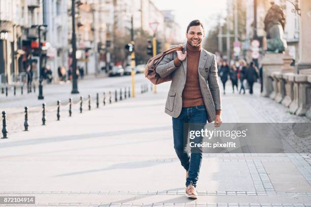 junger mann mit tasche auf der straße - vorderasiatische abstammung stock-fotos und bilder