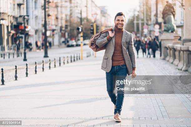 young man with bag walking on the street - smart casual walking stock pictures, royalty-free photos & images