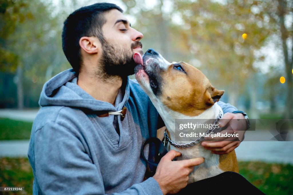 Jovem, movimentando-se com o seu cão no parque