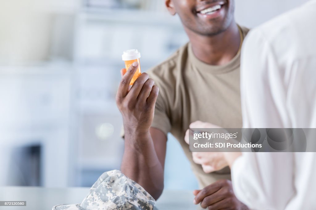 Unrecognizable smiling military patient receives medication