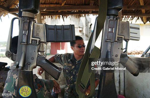 Filipino army soldier sits at a checkpoint June 29, 2002 on the southern island of Jolo, the Philippines. Philippine army scout rangers are tracking...