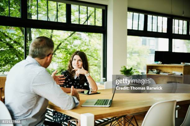 business colleagues having planning meeting in small office conference room - colleagues in discussion in office conference room stockfoto's en -beelden