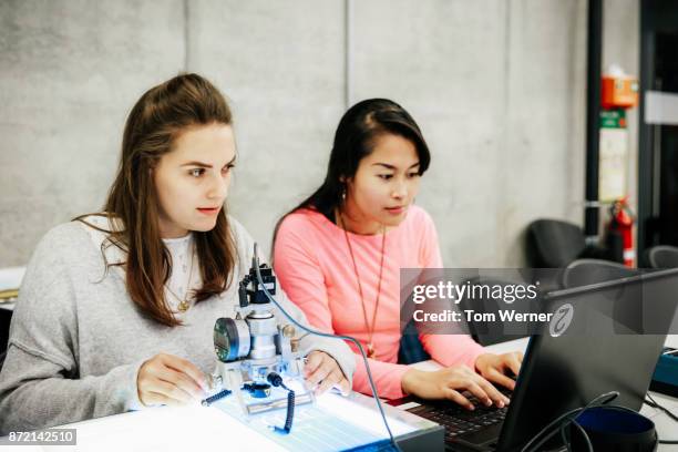 university students working with complex equipment during experiment - mint stock-fotos und bilder