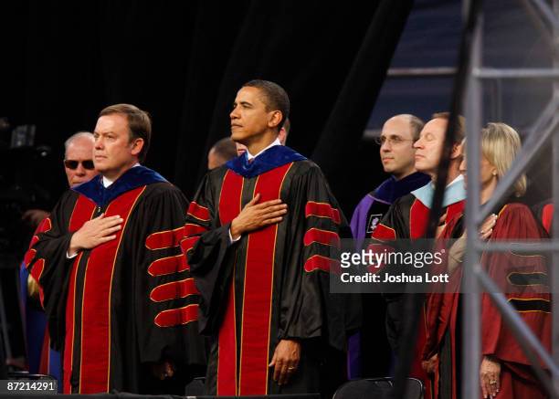 President Barack Obama places his hand over his heart with Arizona State University President Michael Crow during the National Anthem before...