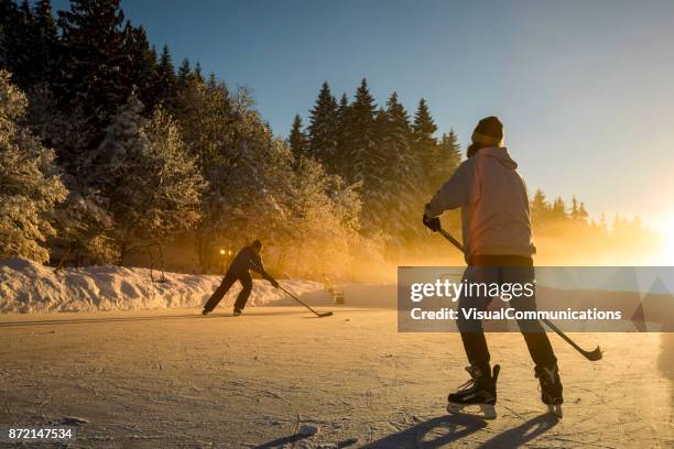 whistler, bc: pond hockey on alta lake. - outdoor ice hockey stock pictures, royalty-free photos & images