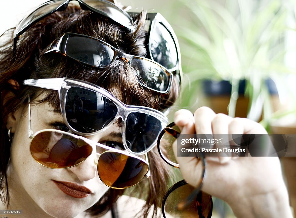 Several Pairs of Sunglasses on One Head