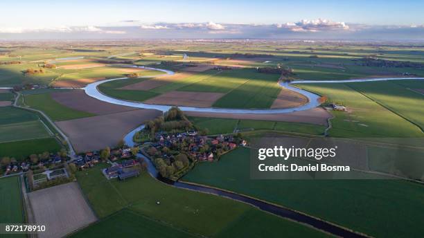 a river curving it's way through a cultivated dutch landscape, seen from the air - groningen city stock-fotos und bilder