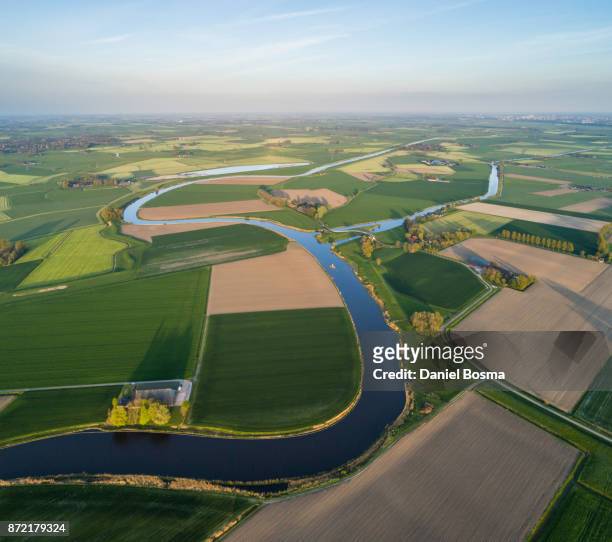 natural curves of a river surrounded by a cultivated dutch landscape, seen from the air - groningen city stock-fotos und bilder