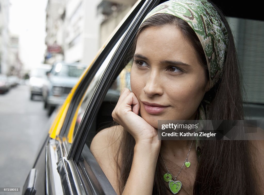 Young woman looking out of taxi window