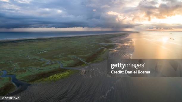 aerial view over schiermonnikoog island during a stunning sunrise with a spectacular sky - netherlands beach stock pictures, royalty-free photos & images