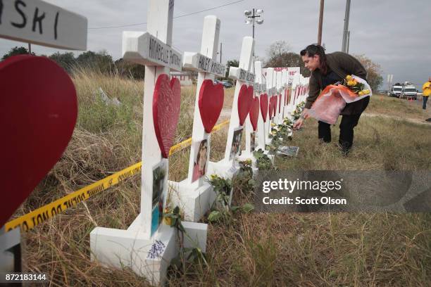 Joyce Mires leaves flowers at a memorial where 26 crosses were placed to honor the 26 victims killed at the First Baptist Church of Sutherland...