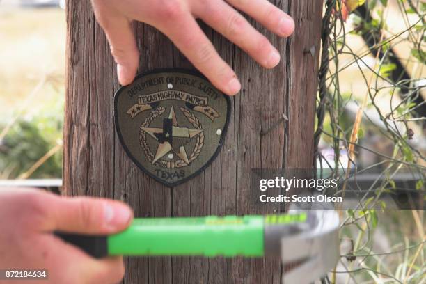 Police officer nails a Texas Highway Patrol patch to a power pole at a memorial to the 26 victims killed at the First Baptist Church of Sutherland...