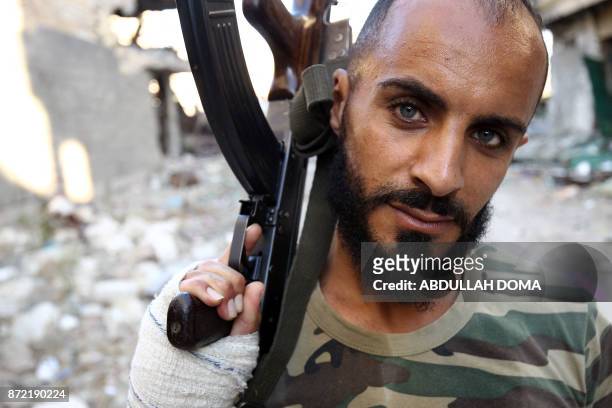Member of the self-styled Libyan National Army, loyal to the country's east strongman Khalifa Haftar, poses with a Kalashnikov assault rifle as he...