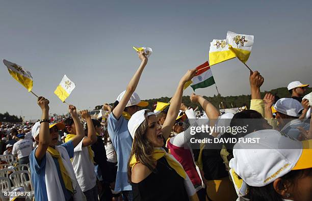 Pilgrims wave Vatican and one Mexican flag as they cheer the arrival of Pope Benedict XVI for a Mass on Mount Precipice, just outside the city of...