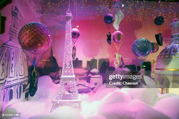 An Eiffel tower covered with snow is displayed inside the Christmas window of the "Le Printemps Haussmann" department store after the inauguration of...