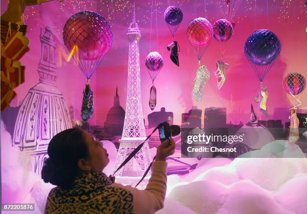 Visitor takes a picture of the Christmas window display of the "Le Printemps Haussmann" department store after the inauguration of the store's...