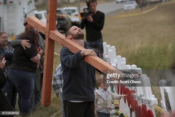 Joshua John of Roanoke, Virginia prays at a memorial where 26 crosses were placed to honor the 26 victims killed at the First Baptist Church of...