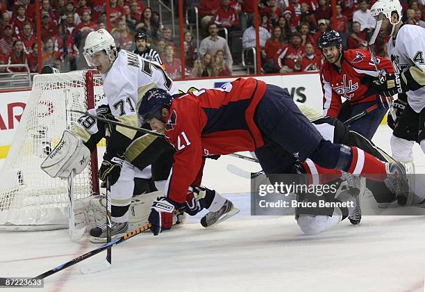 Brooks Laich of the Washington Capitals is tripped up in his game against Evgeni Malkin and the Pittsburgh Penguins during Game Seven of the Eastern...