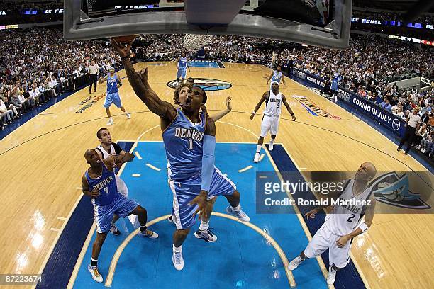 Guard J.R. Smith of the Denver Nuggets takes a shot against Dirk Nowitzki of the Dallas Mavericks in Game Four of the Western Conference Semifinals...