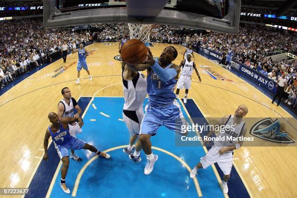 Guard J.R. Smith of the Denver Nuggets takes a shot against Dirk Nowitzki of the Dallas Mavericks in Game Four of the Western Conference Semifinals...