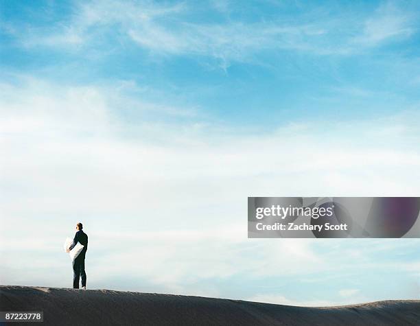 man in pajamas with pillow in desert - schlafwandeln stock-fotos und bilder