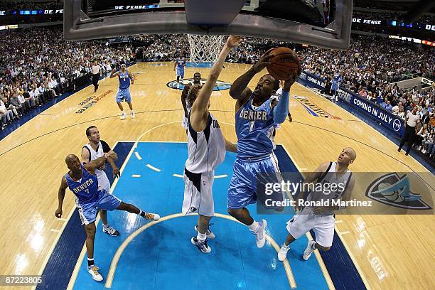 Guard J.R. Smith of the Denver Nuggets takes a shot against Dirk Nowitzki of the Dallas Mavericks in Game Four of the Western Conference Semifinals...