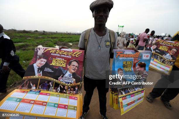 Vendor sells posters with photographs of German pentecostal evangelist Reinhard Bonnke and his successor Daniel Kolenda ahead of the "farewell gospel...