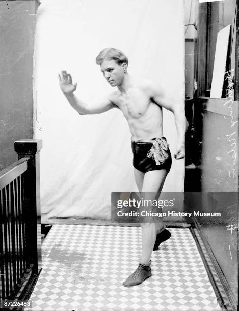 Full-length portrait of Oscar 'Battling' Nelson, boxer and lightweight champion, standing with right arm raised and left arm drawn back in a...