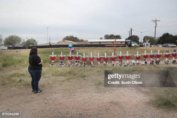 Charlene Uhl stares at a cross with the name and picture of her 16-year-old daughter, Haley Krueger, at a memorial where 26 crosses were placed to...