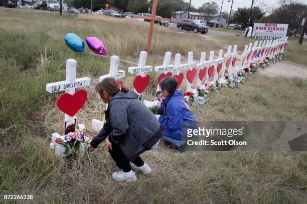 Visitors leave flowers at a memorial where 26 crosses were placed to honor the 26 victims killed at the First Baptist Church of Sutherland Springs on...