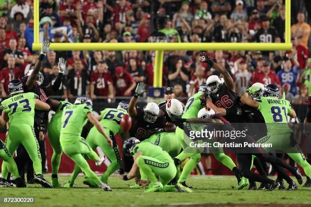 Nose tackle Corey Peters, inside linebacker Kareem Martin and cornerback Justin Bethel of the Arizona Cardinals attempt block a field goal kicked by...
