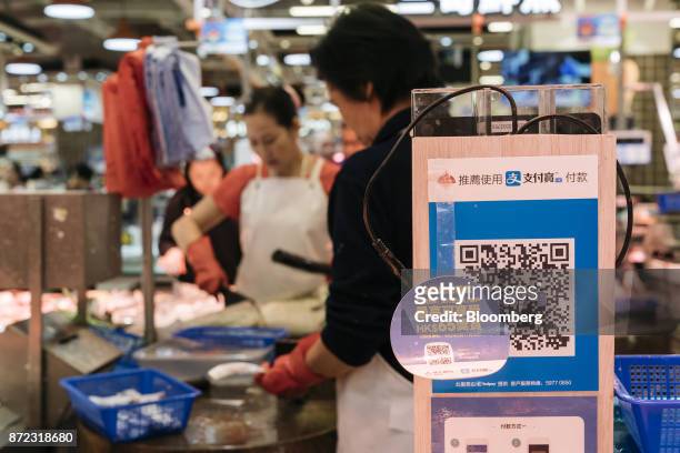 Merchant quick response code for Ant Financial Services Group's Alipay, an affiliate of Alibaba Group Holding Ltd., is displayed at a fish stall...