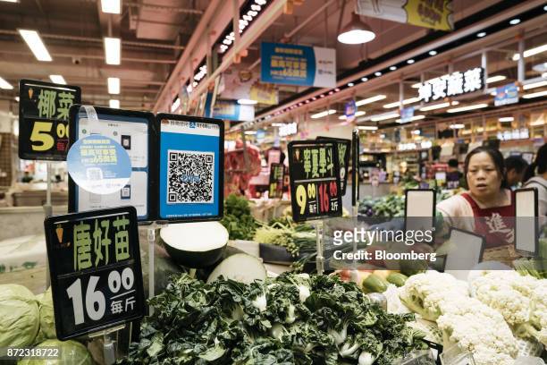 Merchant quick response code for Ant Financial Services Group's Alipay, an affiliate of Alibaba Group Holding Ltd., is displayed next to price signs...