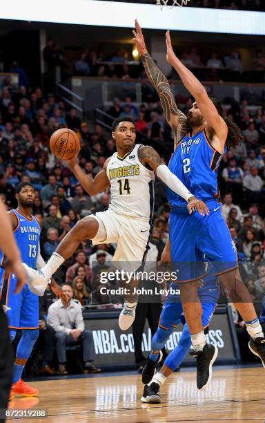 Denver Nuggets guard Gary Harris flies through the air past Oklahoma City Thunder center Steven Adams to throw a pass to the outside during the first...