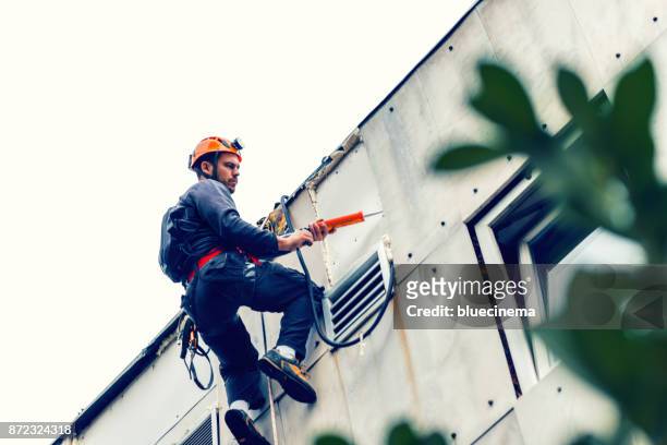 abseiling building maintenance workers at work - facade cleaning stock pictures, royalty-free photos & images