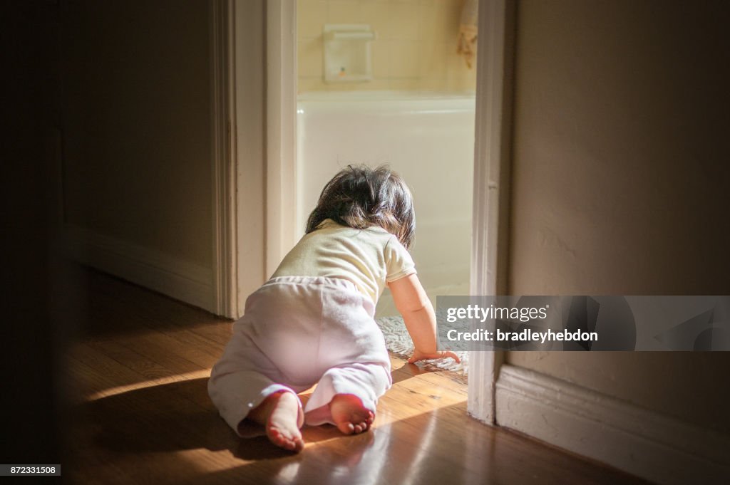 Baby girl crawling through passage in home