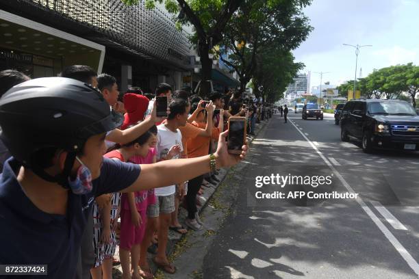 Vietnamese line the street as the convey transporting US President Donald Trump passes by, after his arrival for the Asia-Pacific Economic...