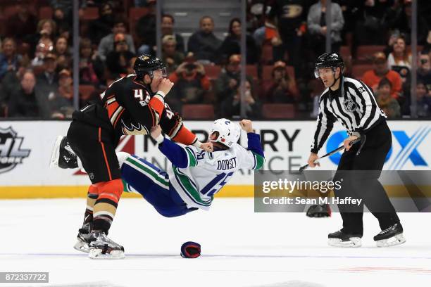 Josh Manson of the Anaheim Ducks fights Derek Dorsett of the Vancouver Canucks as linesman Bryan Pancich looks on during the third period of a game...