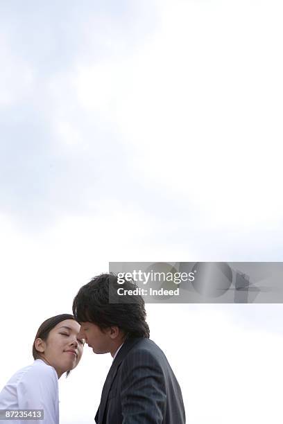 young couple lissing, low angle view - hawaii hemd stock-fotos und bilder