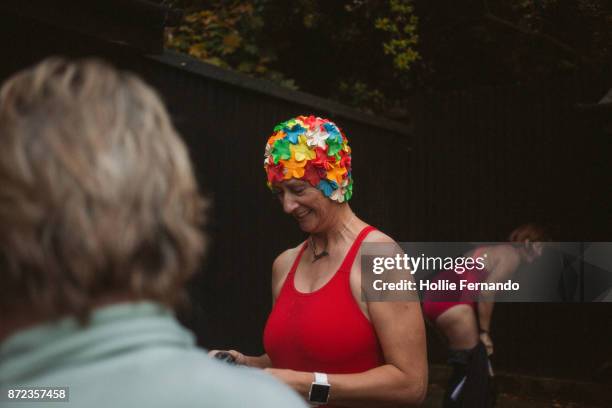 wild swimming women's group autumnal swim - swimming cap stock pictures, royalty-free photos & images