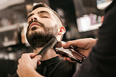Man getting his beard trimmed with electric razor