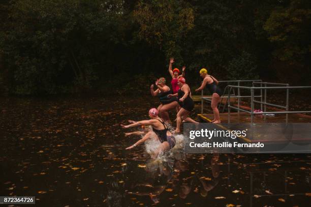 wild swimming women's group autumnal swim - splashed water leaf stock-fotos und bilder