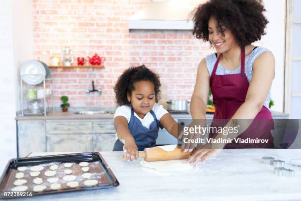 mère et fille à l’aide du rouleau à pâtisserie et faire des biscuits - rolling pin photos et images de collection