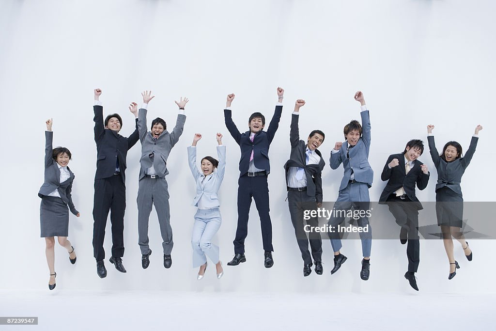 Business people jumping and clenching fists